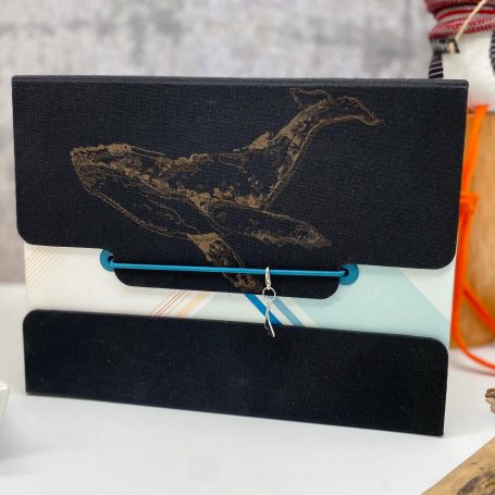 Schwarze Mappe mit Wal-Motiv und bunten Akzenten im Hintergrund.